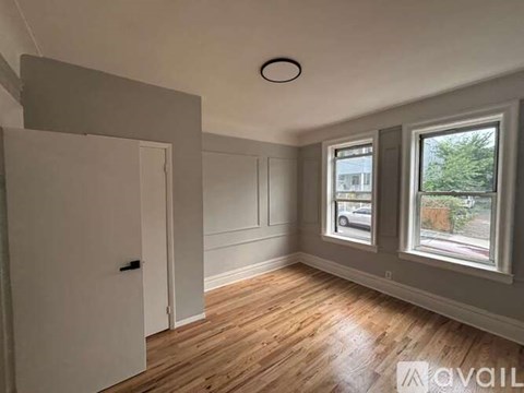 A room with a wooden floor and a window showing a street view.