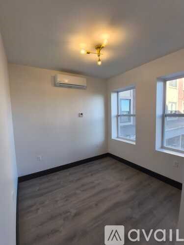 A room with a window and a wall-mounted air conditioner.