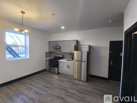 A kitchen area with a stainless steel refrigerator, oven, and microwave.