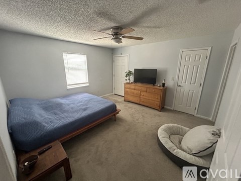 A bedroom with a bed, dresser, and television.