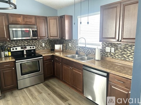 A kitchen with wooden cabinets and a stainless steel dishwasher.
