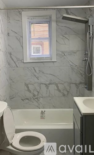 A bathroom with a toilet, sink, and bathtub.