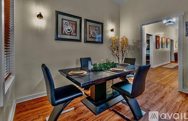 A dining room with a table set for two and two chairs.