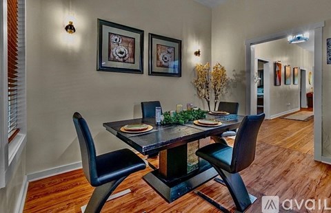 A dining room with a table set for two and two chairs.