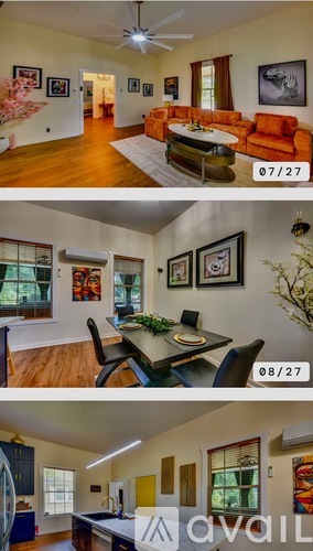 A living room with a couch, a dining table with chairs, and pictures on the wall.