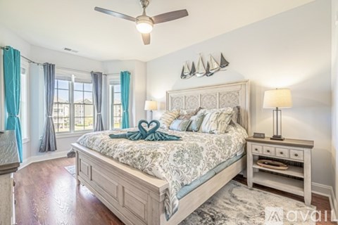 A bedroom with a large bed and a ceiling fan.