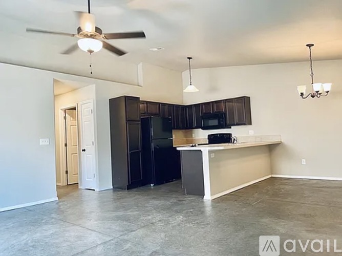 A kitchen with a black refrigerator and a white countertop.