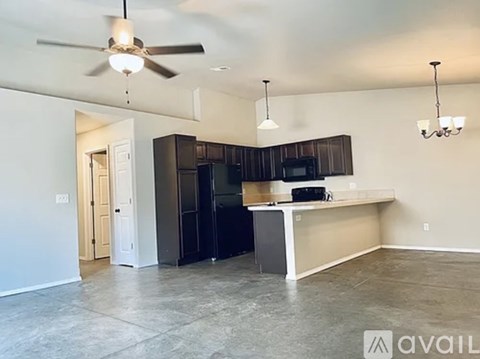 A kitchen with a black refrigerator and a white countertop.