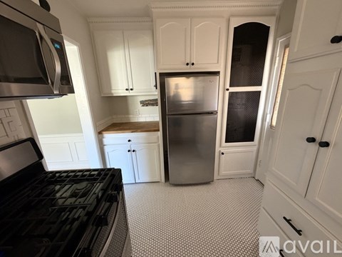 A kitchen with white cabinets and a black stove top.