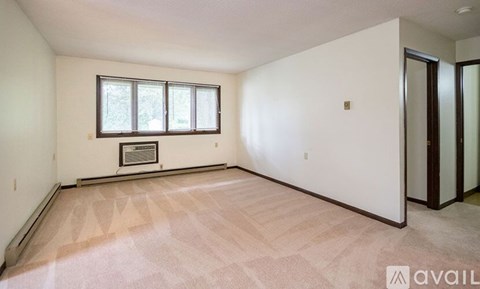 A room with a window and a door is available for rent.