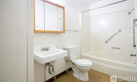 A white bathroom with a toilet, sink, and bathtub.