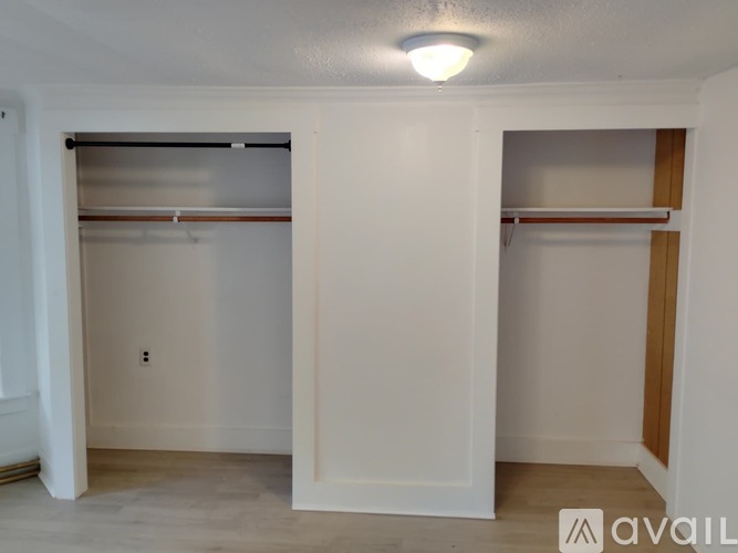 A white bedroom with a bed and a closet.
