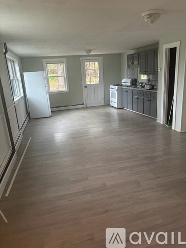 A kitchen with a refrigerator, sink, and cabinets.