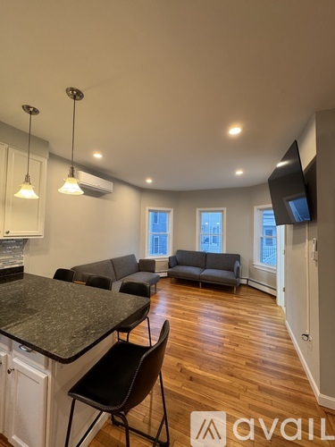 A living room with a grey couch and a black chair.