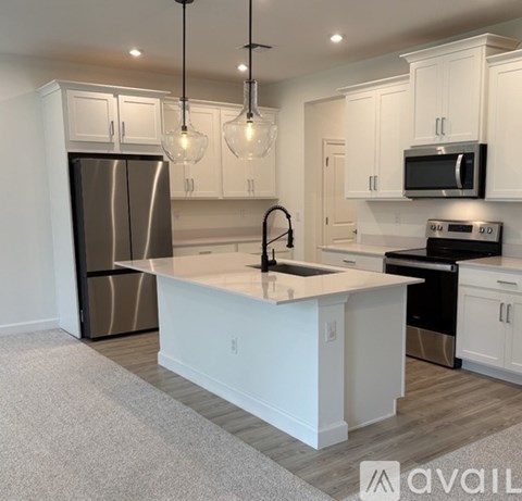 A kitchen with white cabinets and a large island in the middle.