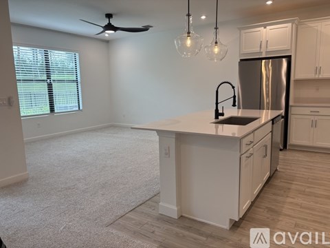 A kitchen with a white countertop and a stainless steel refrigerator.