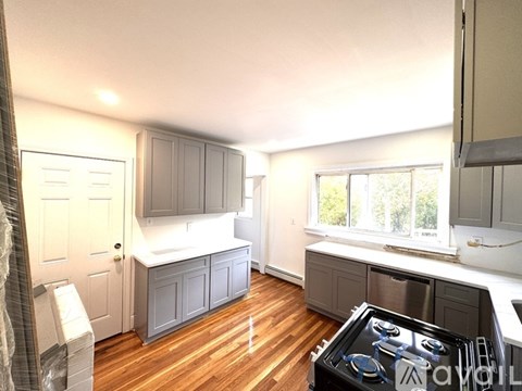 A kitchen with wooden floors and a stove top oven.