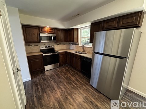 A kitchen with a refrigerator, stove, and sink.