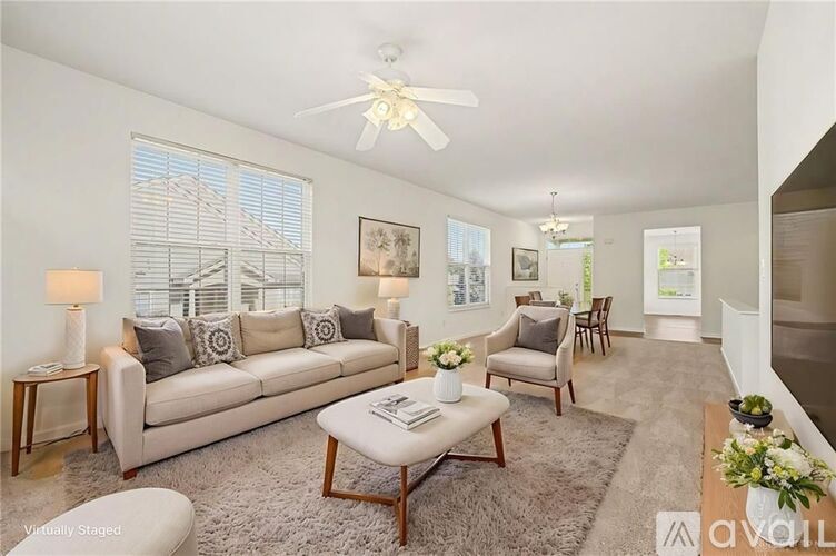 A living room with a grey sofa, a coffee table, and a ceiling fan.