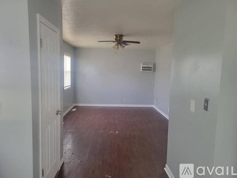 A room with a ceiling fan and wooden flooring.