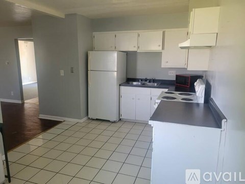 A kitchen with white appliances and cabinets.