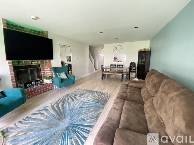 A living room with a brown couch and a blue rug.