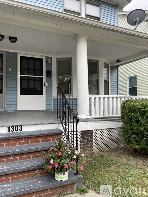 A house numbered 1303 has a flower pot on the steps.