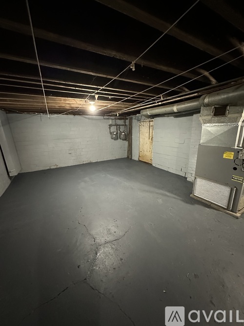 A spacious, unfinished basement with concrete floors and walls, and exposed ductwork on the ceiling.