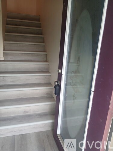 A set of stairs with a glass door leading to a bathroom.