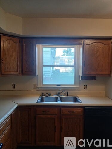A kitchen with wooden cabinets and a window.