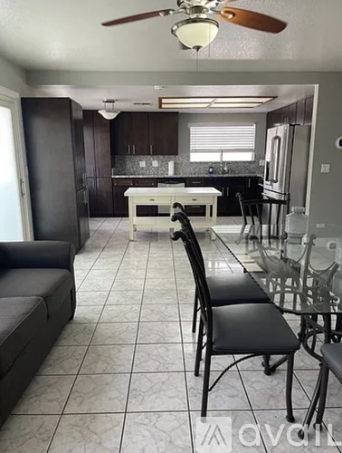 A kitchen with a table and chairs in the foreground.