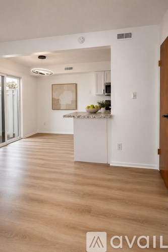 A kitchen with a white counter and a framed picture on the wall.