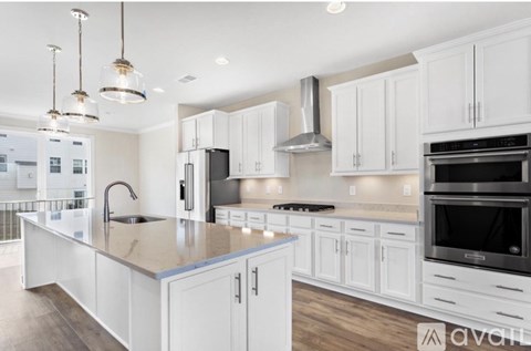 A modern kitchen with white cabinets and a large island.