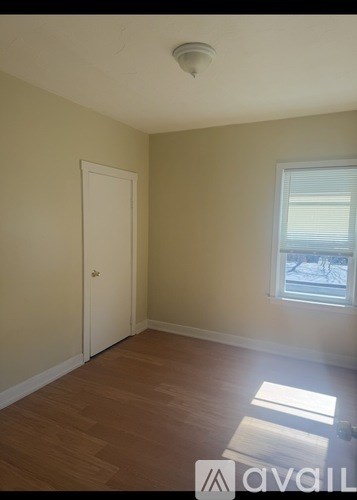 A room with a door, window, and a rug on the floor.