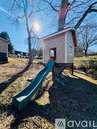 A playground with a slide and a treehouse.