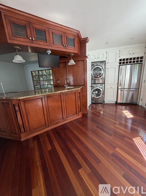 A kitchen with wooden cabinets and a wooden floor.
