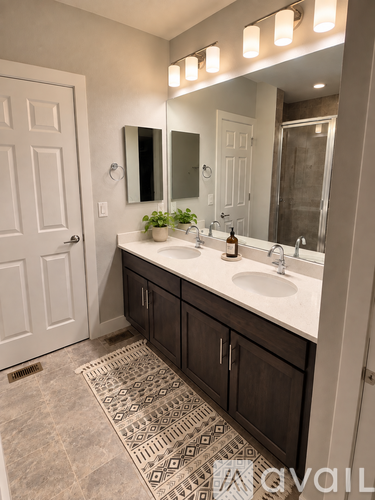 A bathroom with a vanity, sink, mirror, and lights.