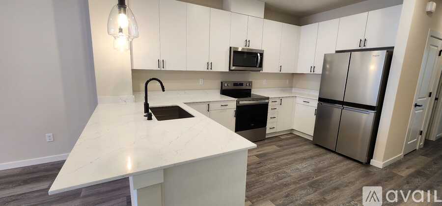 A kitchen with white cabinets and a marble countertop.