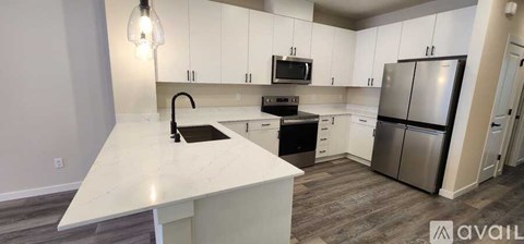A kitchen with white cabinets and a marble countertop.