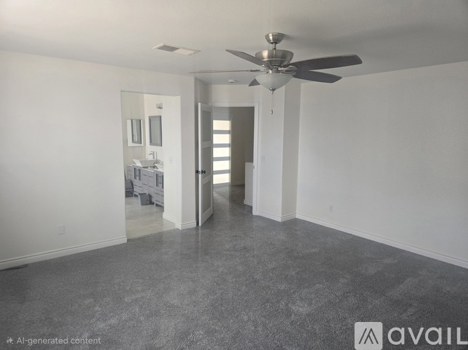 A spacious room with a ceiling fan and a bathroom visible through the door.