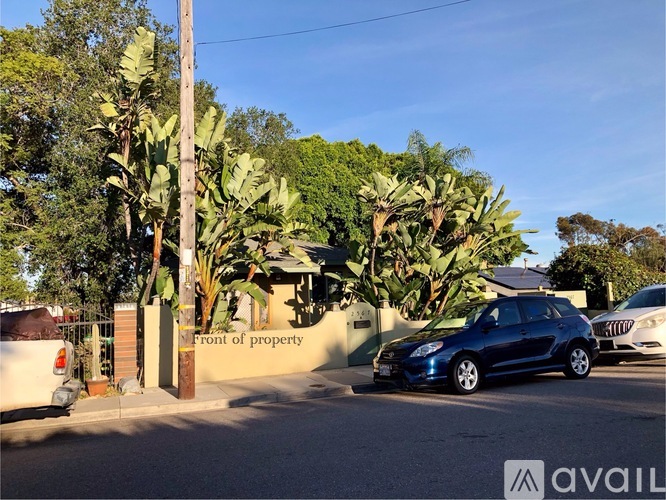 A blue car is parked in front of a property with a sign that reads "Front of property".