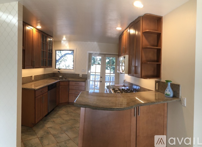 A kitchen with wooden cabinets and a granite countertop.