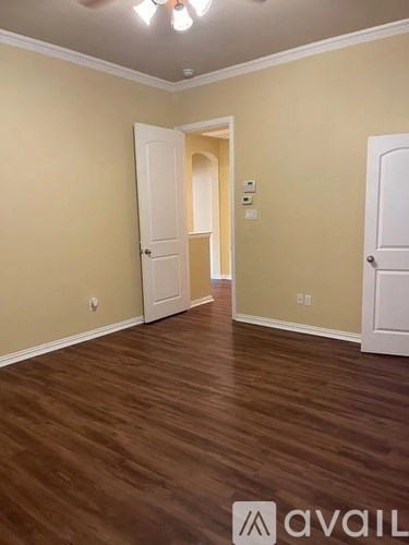 A room with wooden floors and two white doors.