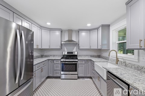 A modern kitchen with a stainless steel refrigerator and a checkered floor.
