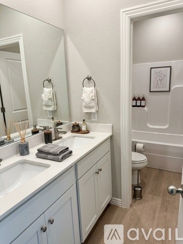 A bathroom with a white sink and toiletries on the counter.