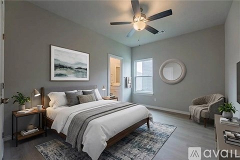 A bedroom with a large bed and a ceiling fan.