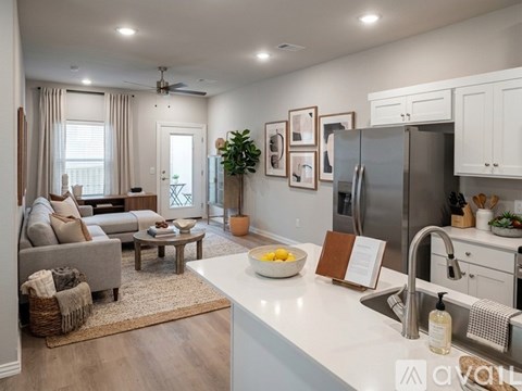A kitchen with a refrigerator, sink, and a dining table with chairs.