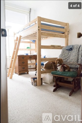 A room with a bunk bed, a chair, and a ladder.