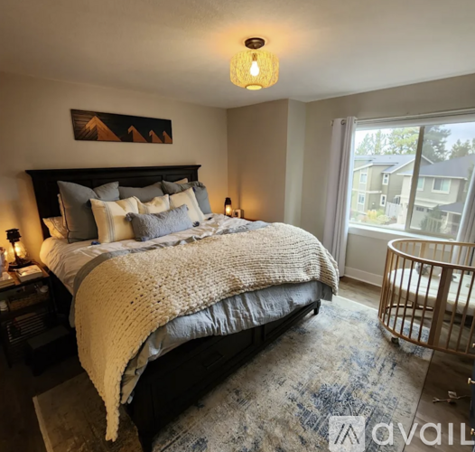 A bedroom with a large bed and a window overlooking a balcony.