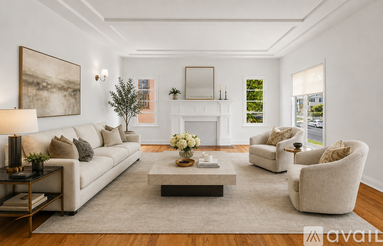 A living room with a white couch, a coffee table, and a fireplace.